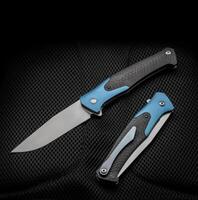 Folding pocket knife with a clip on a dark back. Handle with carbon and color inserts. photo