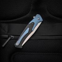 Folding pocket knife with a clip on a dark back. Handle with carbon and color inserts. photo