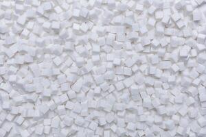 Rafinated sugar. Textured white background from sugar cubes. photo
