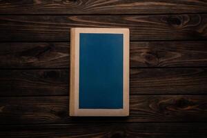Closed book on vintage wooden back. Old book on the wooden table. Closed book with empty cover laying on wooden table. photo