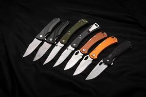 Various folding pocket knives on a dark back. A versatile pocket tool and self-defense tool. photo
