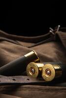Shotgun shells close-up. Ammunition for smoothbore weapons on a khaki canvas backpack. Dark back photo