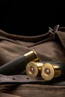 Shotgun shells close-up. Ammunition for smoothbore weapons on a khaki canvas backpack. Dark back photo