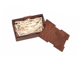 Open wooden box with filling material inside. Empty natural wooden box with decorative straw for happy gifts. photo