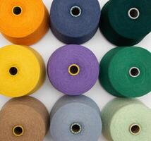 Multi-colored bobbins of yarn on a white background. Top view on colored spools of thread.Textile reels on white background. photo