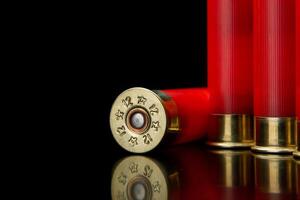 Shotgun shells on a black reflective surface. Ammunition for 12 gauge smoothbore weapons. Hunting ammunition. Dark back. photo