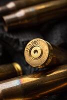 Empty shells from weapons on black smoldering coals. Consequences of the war. Dark back. photo