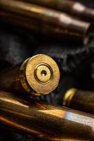 Empty shells from weapons on black smoldering coals. Consequences of the war. Dark back. photo