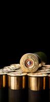 Shotgun shells on a black reflective surface. Ammunition for 12 gauge smoothbore weapons. Hunting ammunition. Dark back. photo