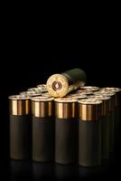 Shotgun shells on a black reflective surface. Ammunition for 12 gauge smoothbore weapons. Hunting ammunition. Dark back. photo