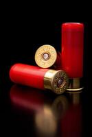 Shotgun shells on a black reflective surface. Ammunition for 12 gauge smoothbore weapons. Hunting ammunition. Dark back. photo