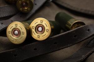 Shotgun shells close-up. Ammunition for smoothbore weapons on a khaki canvas backpack. Dark back. photo