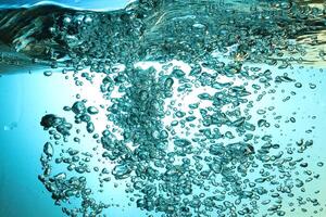 Fresh Water With Underwater Bubbles Texture on a Blue Background Close-up Abstract Liquid Bubbles Aqua Design Wallpaper photo