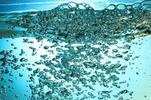 Fresh Water With Underwater Bubbles Texture on a Blue Background Close-up Abstract Liquid Bubbles Aqua Design Wallpaper photo