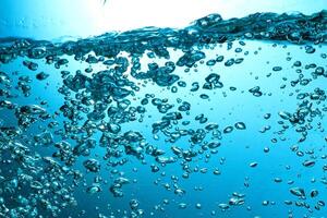 Fresh Water With Underwater Bubbles Texture on a Blue Background Close-up Abstract Liquid Bubbles Aqua Design Wallpaper photo