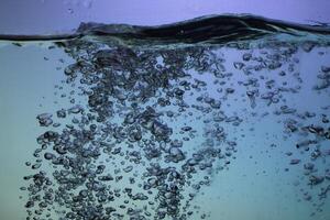 Fresh Water With Underwater Bubbles Texture on a Blue Background Close-up Abstract Liquid Bubbles Aqua Design Wallpaper photo