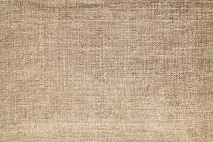 Natural Linen Material Textile Canvas Fabric Texture Background Close-up Detail of Fabric Natural Color Hemp Material Pattern Design Wallpaper. Can be Used as Background or For Graphic Design photo
