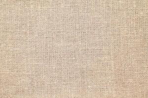 Natural Linen Material Textile Canvas Fabric Texture Background Close-up Detail of Fabric Natural Color Hemp Material Pattern Design Wallpaper. Can be Used as Background or For Graphic Design photo