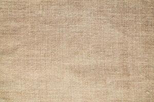 Natural Linen Material Textile Canvas Fabric Texture Background Close-up Detail of Fabric Natural Color Hemp Material Pattern Design Wallpaper. Can be Used as Background or For Graphic Design photo