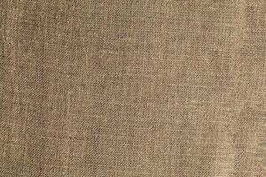 Natural Linen Material Textile Canvas Fabric Texture Background Close-up Detail of Fabric Natural Color Hemp Material Pattern Design Wallpaper. Can be Used as Background or For Graphic Design photo