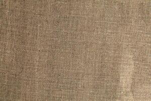 Natural Linen Material Textile Canvas Fabric Texture Background Close-up Detail of Fabric Natural Color Hemp Material Pattern Design Wallpaper. Can be Used as Background or For Graphic Design photo