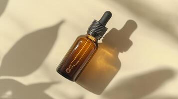 A brown glass bottle with an amber dropper for skin care on beige background. photo