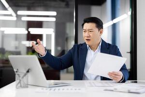 A confused and overwhelmed businessman working in the office, expressing frustration and dissatisfaction with work. photo