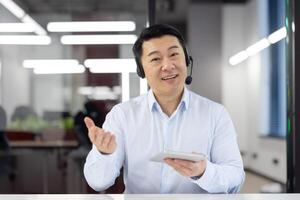 Smiling male customer service agent with headset in office environment, assisting clients with enthusiasm and professionalism. photo