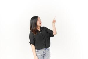 Young Asian woman showing product and pointing up copy space wearing Black t-shirt and jeans isolated on white background photo