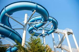 Water Slide, Amusement Park, Summer Fun - A blue water slide at an amusement park on a sunny summer day. photo
