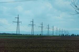 High voltage towers with sky background. Power line support with wires for electricity transmission. High voltage grid tower with wire cable at distribution station. Energy industry, energy saving photo