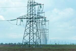 High voltage towers with sky background. Power line support with wires for electricity transmission. High voltage grid tower with wire cable at distribution station. Energy industry, energy saving photo
