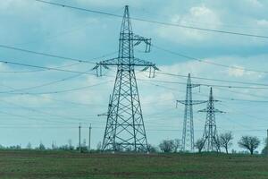 High voltage towers with sky background. Power line support with wires for electricity transmission. High voltage grid tower with wire cable at distribution station. Energy industry, energy saving photo