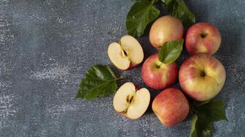 apples with leaves and slices on a dark surface photo