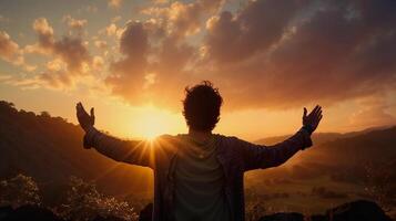 a man with his arms outstretched at sunset photo