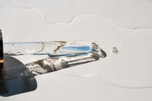 Pipette with serum on a beige background. photo