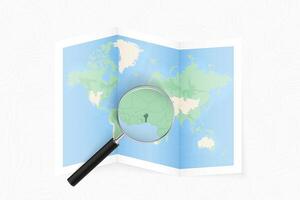 Enlarge Benin with a magnifying glass on a folded map of the world. vector
