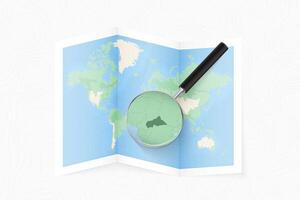 Enlarge Central African Republic with a magnifying glass on a folded map of the world. vector