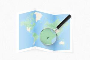 Enlarge Uganda with a magnifying glass on a folded map of the world. vector