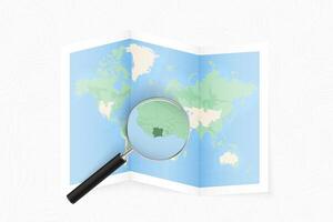 Enlarge Ivory Coast with a magnifying glass on a folded map of the world. vector