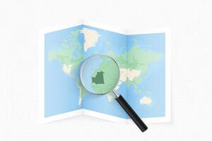 Enlarge Mauritania with a magnifying glass on a folded map of the world. vector
