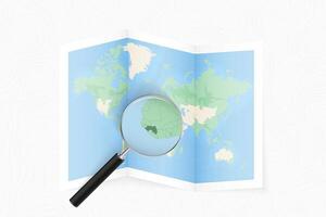 Enlarge Guinea with a magnifying glass on a folded map of the world. vector
