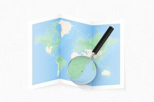 Enlarge Swaziland with a magnifying glass on a folded map of the world. vector