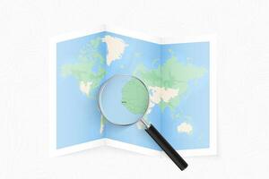 Enlarge Gambia with a magnifying glass on a folded map of the world. vector