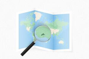 Enlarge Burkina Faso with a magnifying glass on a folded map of the world. vector
