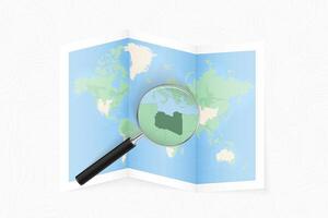 Enlarge Libya with a magnifying glass on a folded map of the world. vector