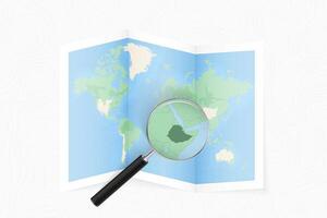 Enlarge Ethiopia with a magnifying glass on a folded map of the world. vector