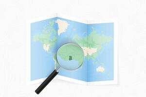 Enlarge Ghana with a magnifying glass on a folded map of the world. vector