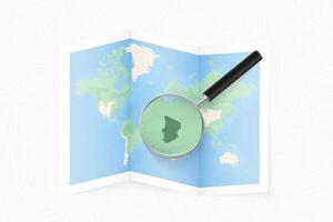 Enlarge Chad with a magnifying glass on a folded map of the world. vector