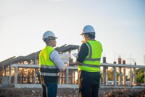 Two architects are inspecting the progress of the construction and checking the completion of the construction photo